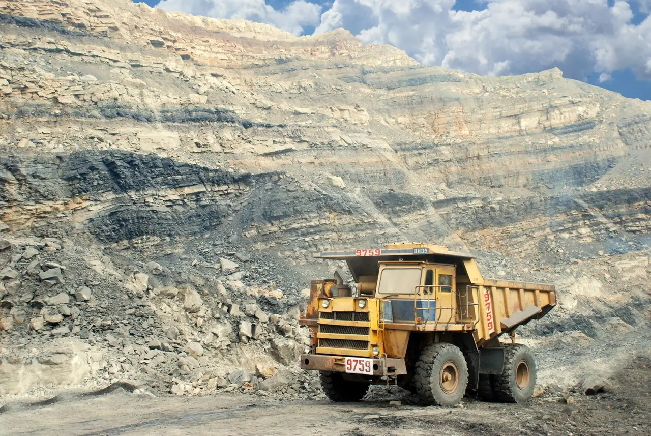 Excavated ore and handling equipment at an open-pit mine; illustrative photograph
